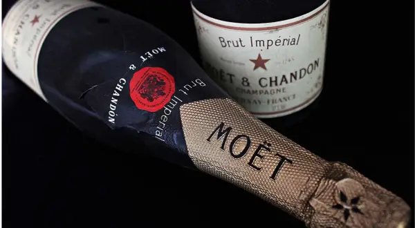 Dwie butelki szampana Moët & Chandon Brut Impérial na czarnym tle. Zastanawiasz się, ile szampan ma procent? Zwykle 12%.
