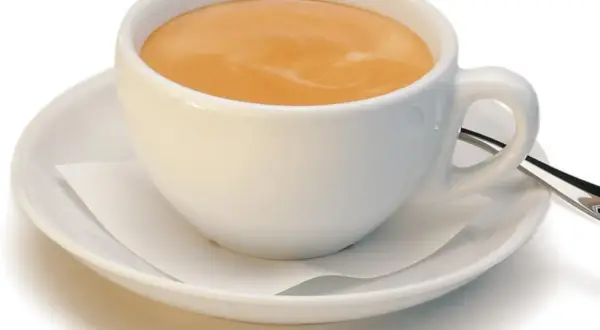 Ein kleiner brauner Kaffee mit Milchschaum in einer weißen Tasse auf einer Untertasse.