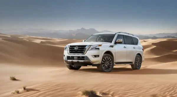 Biały Nissan Armada przemierza piaszczyste wydmy pustyni, gotowy na każdą przygodę.