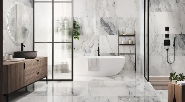 Elegantes combinaciones de azulejos para baños con efecto mármol, bañera exenta y mueble de madera.