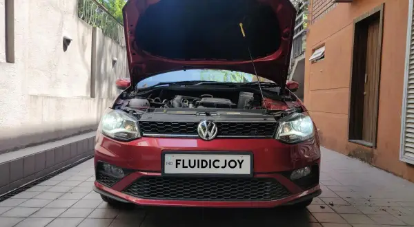 Czerwony VW Polo z otwartą maską, gotowy do wymiany żarówki H7.