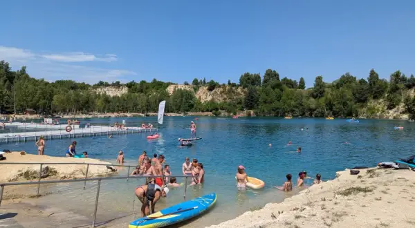 Ludzie kąpią się i pływają na deskach SUP w słoneczny dzień nad zalewem Balaton Trzebinia.