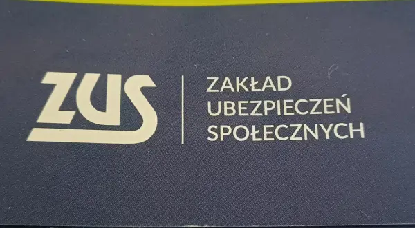 Logo ZUS (Zakład Ubezpieczeń Społecznych) na granatowym tle.