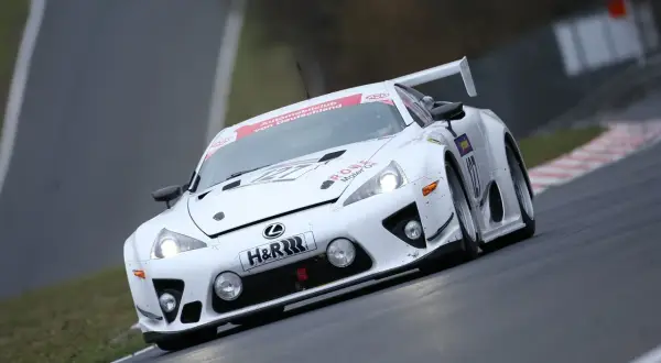 Biały Lexus LFA na torze wyścigowym, z numerem 127 i logiem H&R.
