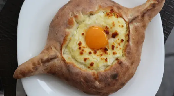 Chaczapuri adżarskie, jeden z popularnych rodzajów chaczapuri, z serem i surowym jajkiem na wierzchu.