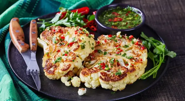 Pyszny obiad z kalafiorem, przyprawionym papryczką chili i ziołami, podany z sosem.