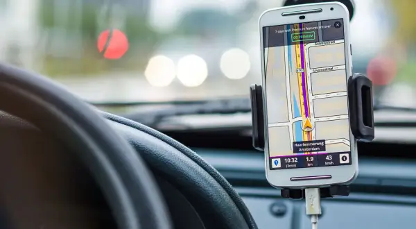 En mobiltelefon med GPS visar vägen i bilen. Föraren kan prata i telefon medan navigeringen pågår.
