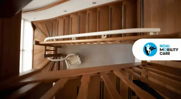 Montascale a poltroncina installato su scala condominiale in legno. Ottenere l'autorizzazione installazione montascale condominio è fondamentale per l'accessibilità.