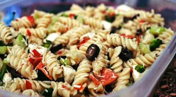 Leckerer Nudelsalat mit Oliven, Paprika und Brokkoli, perfekt als Beilage zum Grillen.