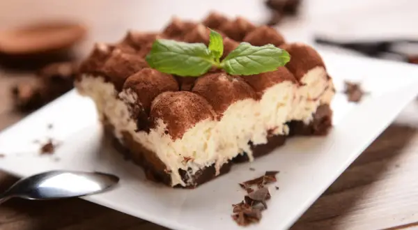 Pyszne tiramisu, posypane kakao i udekorowane miętą. Idealne na deser, choć warto pamiętać o jego tiramisu kcal.