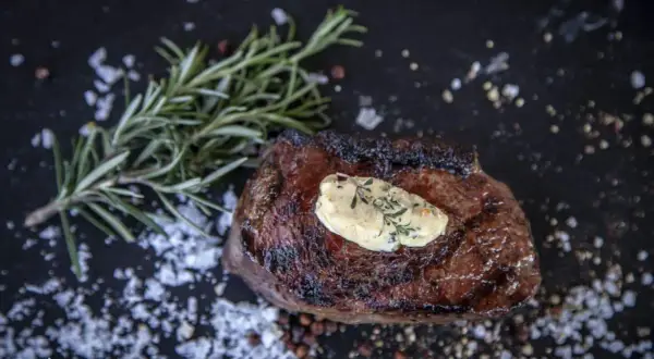 Perfekt medium gegrilltes Steak mit Kräuterbutter, Rosmarin und grobem Salz.