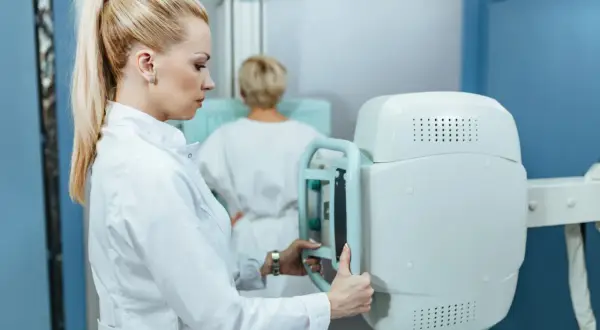 Radiolog przygotowuje aparat do mammografii. Czy mammografia boli? To pytanie zadaje sobie wiele kobiet, ale nowoczesne badania są coraz mniej inwazyjne.