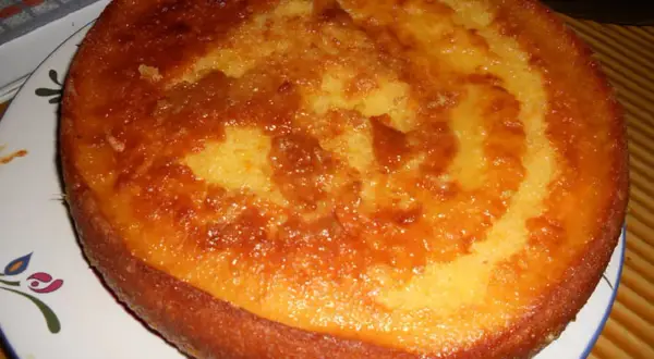 Un délicieux cake à l'orange, doré et moelleux, prêt à être dégusté. Sa croûte caramélisée promet une explosion de saveurs.