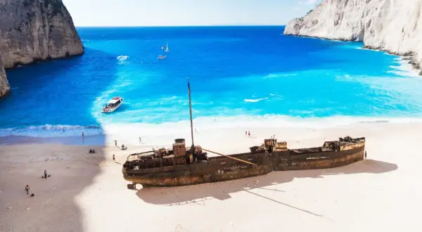 Wrak statku na plaży Navagio, idealne miejsce na kos wycieczki fakultatywne po polsku. Błękitna woda, biały piasek i klify tworzą rajski krajobraz.