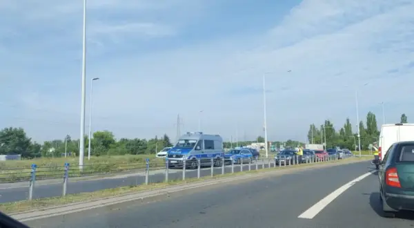 Korki w Toruniu. Policja kieruje ruchem na zakorkowanej drodze.