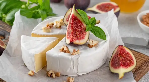 Queso brie cremoso con higos frescos y nueces. ¡La corteza blanca es deliciosa y se come junto con el queso!
