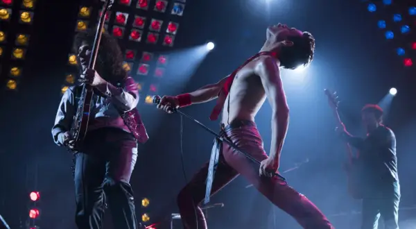 Freddie Mercury śpiewa "Bohemian Rhapsody", a jego zespół gra na żywo. Nuty tej ikonicznej piosenki rozbrzmiewają na koncercie.