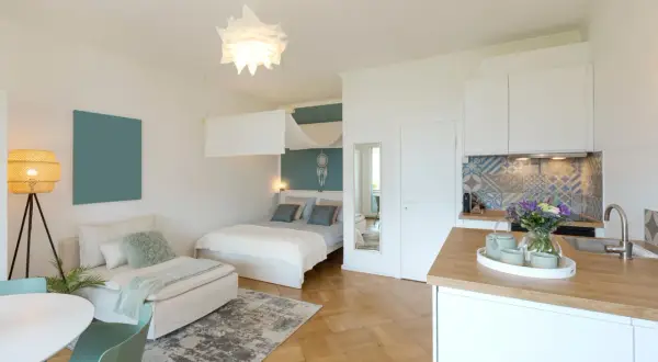 Gemütliche 1 Zimmer Wohnung einrichten 30qm: Bett, Sofa, Küche und Esstisch sind stilvoll integriert.