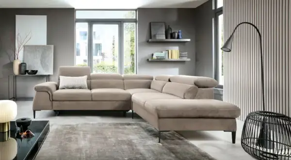 Nowoczesny salon z beżową sofą i dywanem. Inspiracje szare ściany tworzą eleganckie tło dla minimalistycznych dodatków i sztuki.