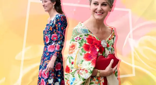 Dos mujeres con atuendos florales. Una luce un vestido azul con flores y la otra un mantón de Manila bordado con pájaros y flores.