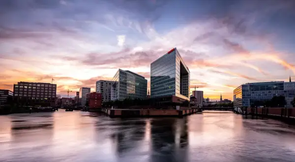 Spektakulärer Sonnenuntergang über Hamburgs moderner Architektur. Ein perfekter Ort für Fotospots Hamburg, mit Spiegelungen im Wasser.