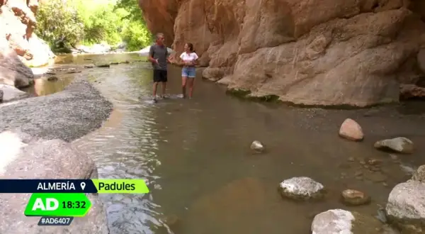 Dos personas caminan por un río en un cañón, explorando qué ver en Padules, Almería.