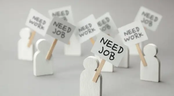 Figurki ludzi z transparentami "NEED JOB" i "NEED WORK". Dowiedz się, jak sprawdzić status bezrobotnego online.