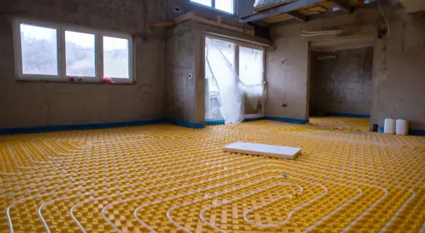 Installazione di un sistema di riscaldamento a pavimento, un'avanzata forma di aria condizionata a pavimento, in un edificio in costruzione.