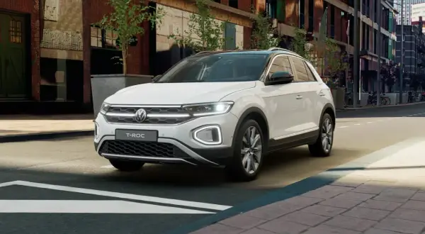 Biały Volkswagen T-Roc stoi na ulicy miejskiej, gotowy na kolejną przygodę.