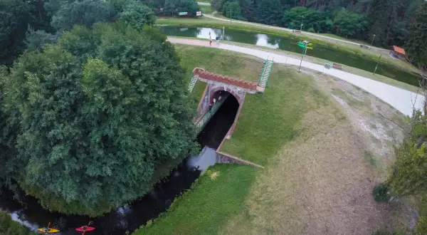 Akwedukt w Fojutowie, gdzie rzeka przepływa pod ziemią, a nad nią rozciąga się malowniczy park z jeziorem i wieżą widokową.