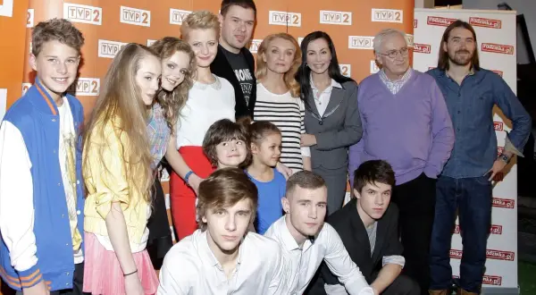 Rodzinka.pl obsada: młodzi i starsi aktorzy pozują do zdjęcia. W tle logo TVP 2 i rodzinka.pl.