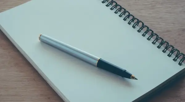 Notatnik i długopis gotowe do napisania podania o przyjęcie na praktyki studenckie.