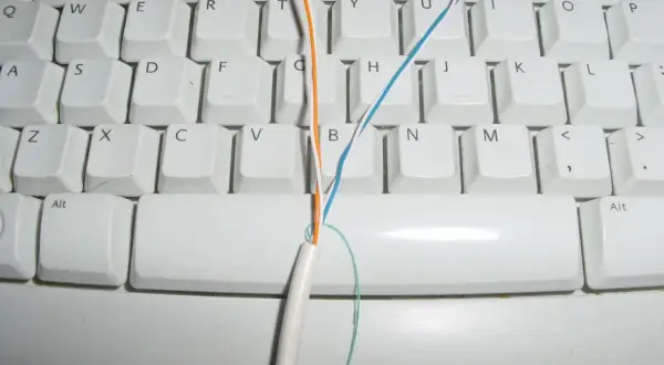 Kabel telefoniczny 4 żyłowy jak podłączyć? Pomarańczowa i niebieska żyła na klawiaturze.