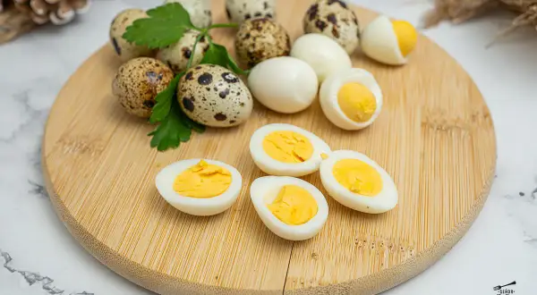 Huevos de codorniz cocidos y cortados por la mitad, mostrando sus yemas amarillas. Perfectos para una tapa o ensalada.