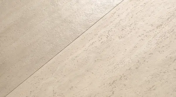 Superficie in pietra chiara, con texture irregolare, che appare satinato o opaco.