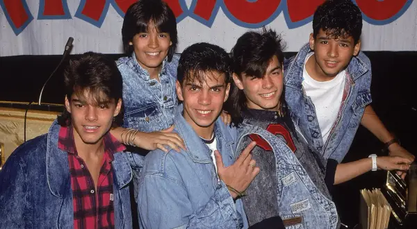Fünf junge Männer in Jeansjacken, die wie eine Boygroup posieren.