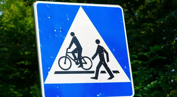 Znak ostrzegawczy: przejazd dla rowerzystów i pieszych. Uważaj na drodze, gdy widzisz ten symbol.