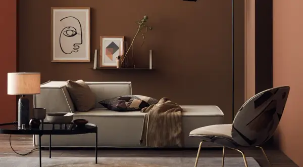 Gemütliches Wohnzimmer in warmem Braunton mit Sofa, Sessel und Kunst.