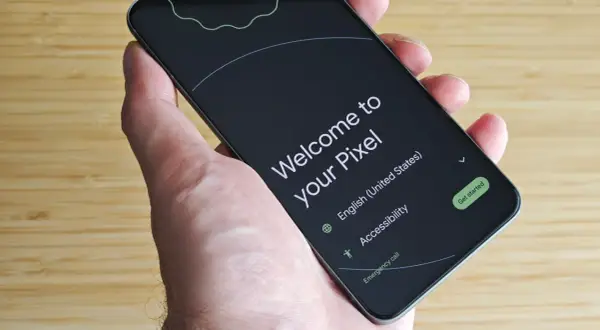 Mano sujetando un Pixel listo para configurar mi dispositivo Android. Pantalla de bienvenida en inglés, con opciones de accesibilidad y llamada de emergencia.