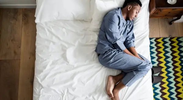 A man sleeps on his side, curled up. What does the way you sleep say about you?