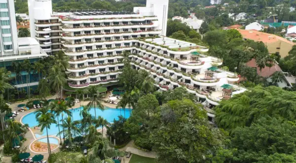 Luksusowy hotel z basenem i palmami, otoczony bujną zielenią, przypomina tropikalny raj, prawdziwe shangri la.