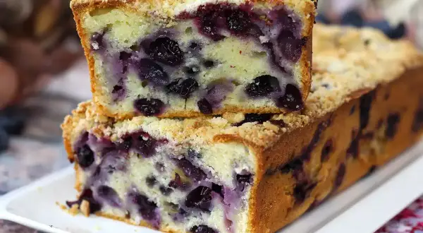 Ein saftiger Blaubeer Streuselkuchen, mit vielen Blaubeeren und knusprigen Streuseln, auf einem weißen Teller.