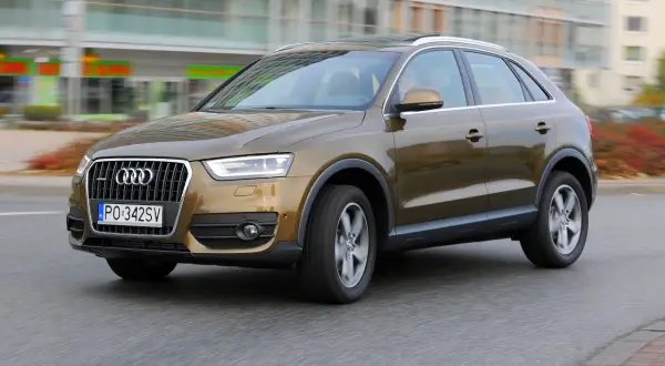 Brązowy Audi Q3 w ruchu miejskim. Kierowca zadowolony, potwierdzają to pozytywne audi q3 opinie.