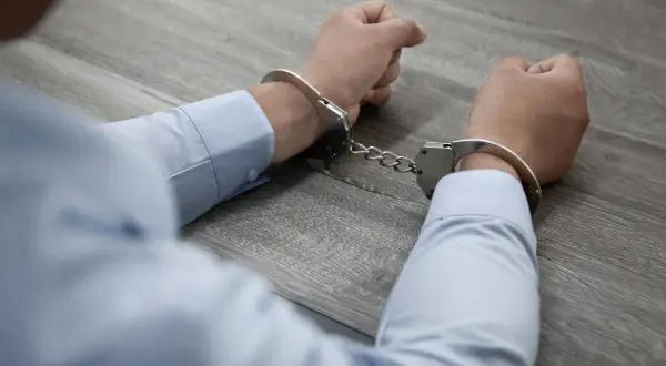 Ręce w kajdankach, symbol końca działalności zorganizowanej grupy przestępczej kk.