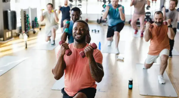 Männer trainieren mit Hanteln im Fitnessstudio. Ob es reicht, eine Muskelgruppe einmal pro Woche zu trainieren, ist eine Frage der Ziele.