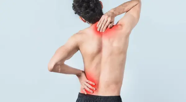 Uomo con dolore alla schiena bassa, evidenziato in rosso. Quanto dura uno strappo muscolare alla schiena bassa?