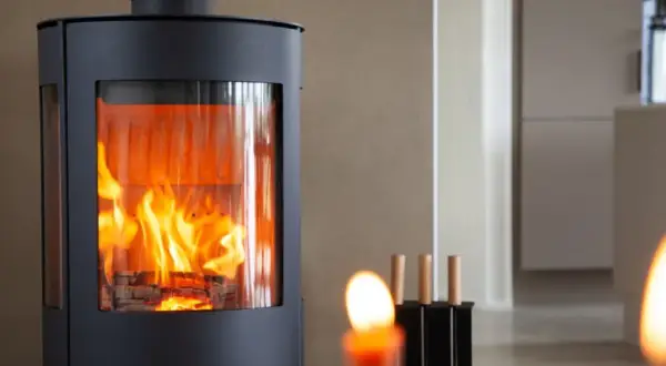 Moderner Kaminofen mit sichtbarem Feuer, erfüllt BIMSCHV Stufe 2. Gemütliches Ambiente im Wohnraum.