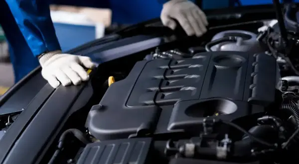 Mechanik w białych rękawiczkach sprawdza silnik Ecotec.