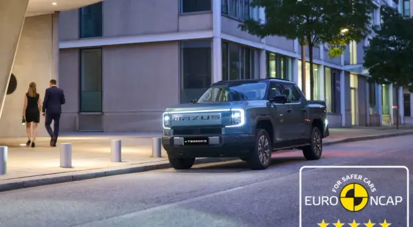 Elegancka para idzie obok nowoczesnego, elektrycznego pickupa Maxus eTerron9. Auto zdobyło 5 gwiazdek w testach Euro NCAP.
