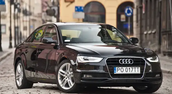Błyszczący czarny Audi A4 b8 na brukowanej ulicy.